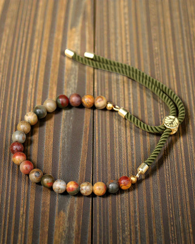 Moss Aura – Armband met Picasso-jaspis en 18K goud aan een groen koordje