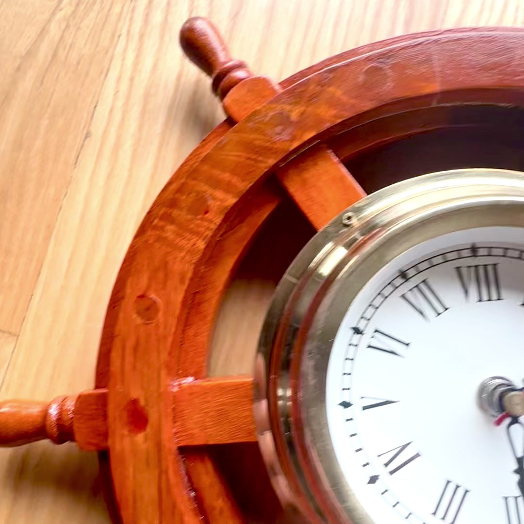 Maritieme klok in een houten stuurwiel van messing